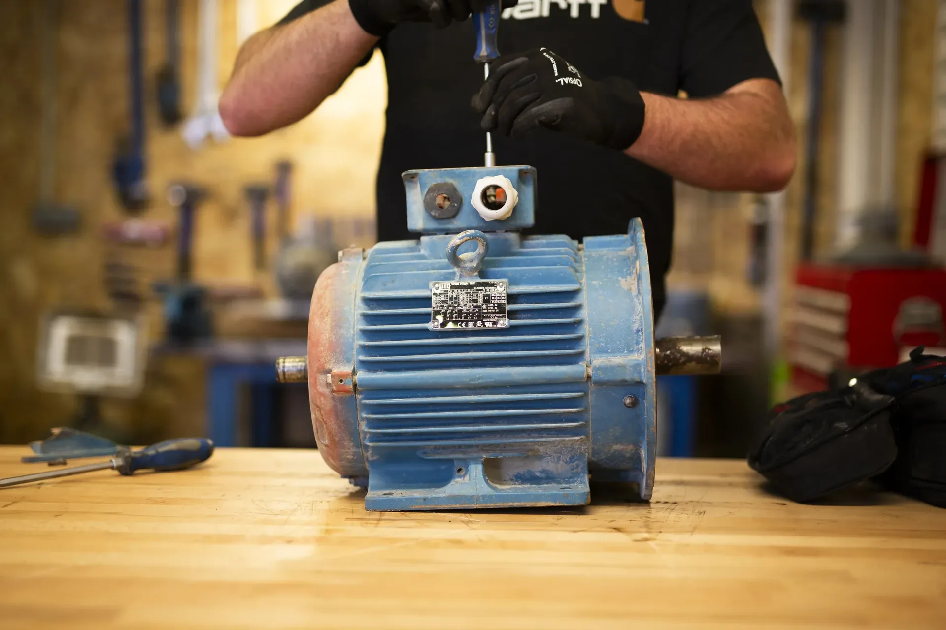 Technicien en atelier procédant à la réparation d'un moteur électrique — TCA Industries
